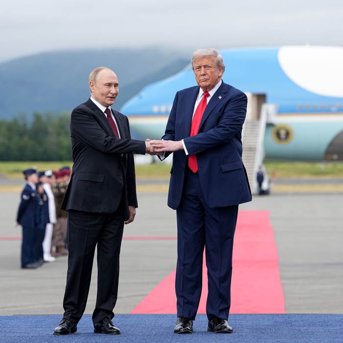 Shaking hands with Air Force One in the background.